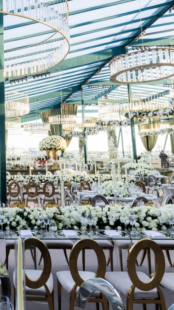 Decoração com flores brancas e estruturas suspensas em casamento de luxo.
